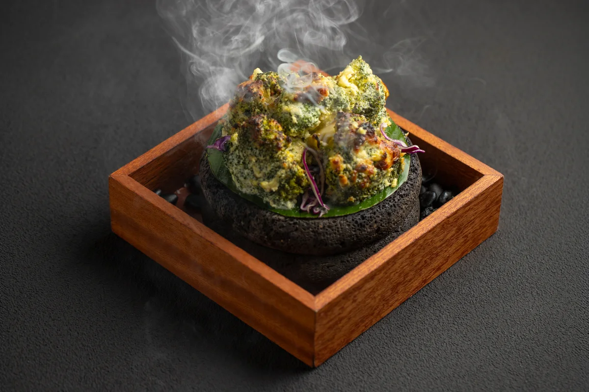 Basil pesto malai broccoli on a smoking stone in a wooden box