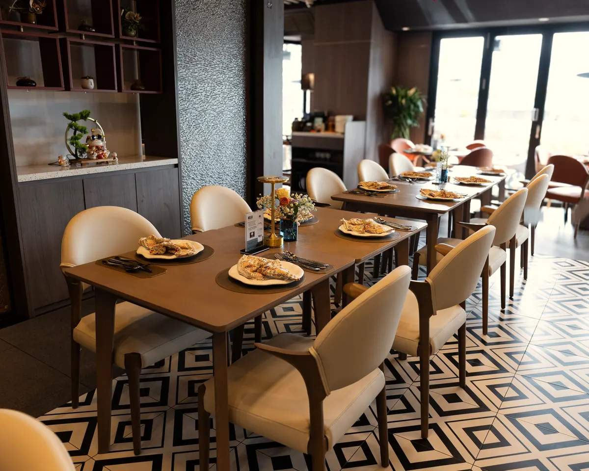Tagline’s dining room: long tables, cream chairs and a patterned tiled floor beside the windows